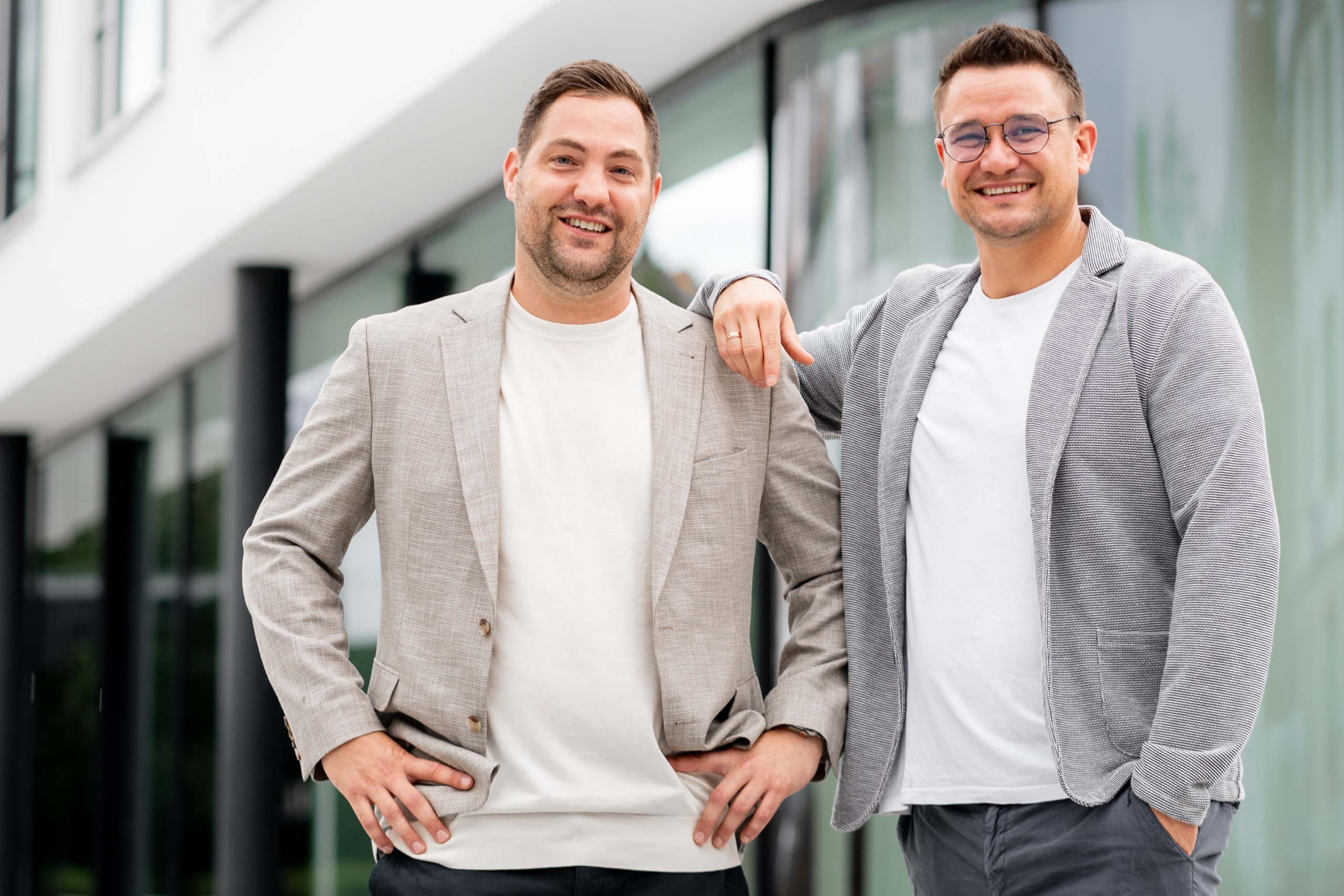 Zwei Ansprechpartner für betriebliche Krankenversicherung vor einem Bürogebäude