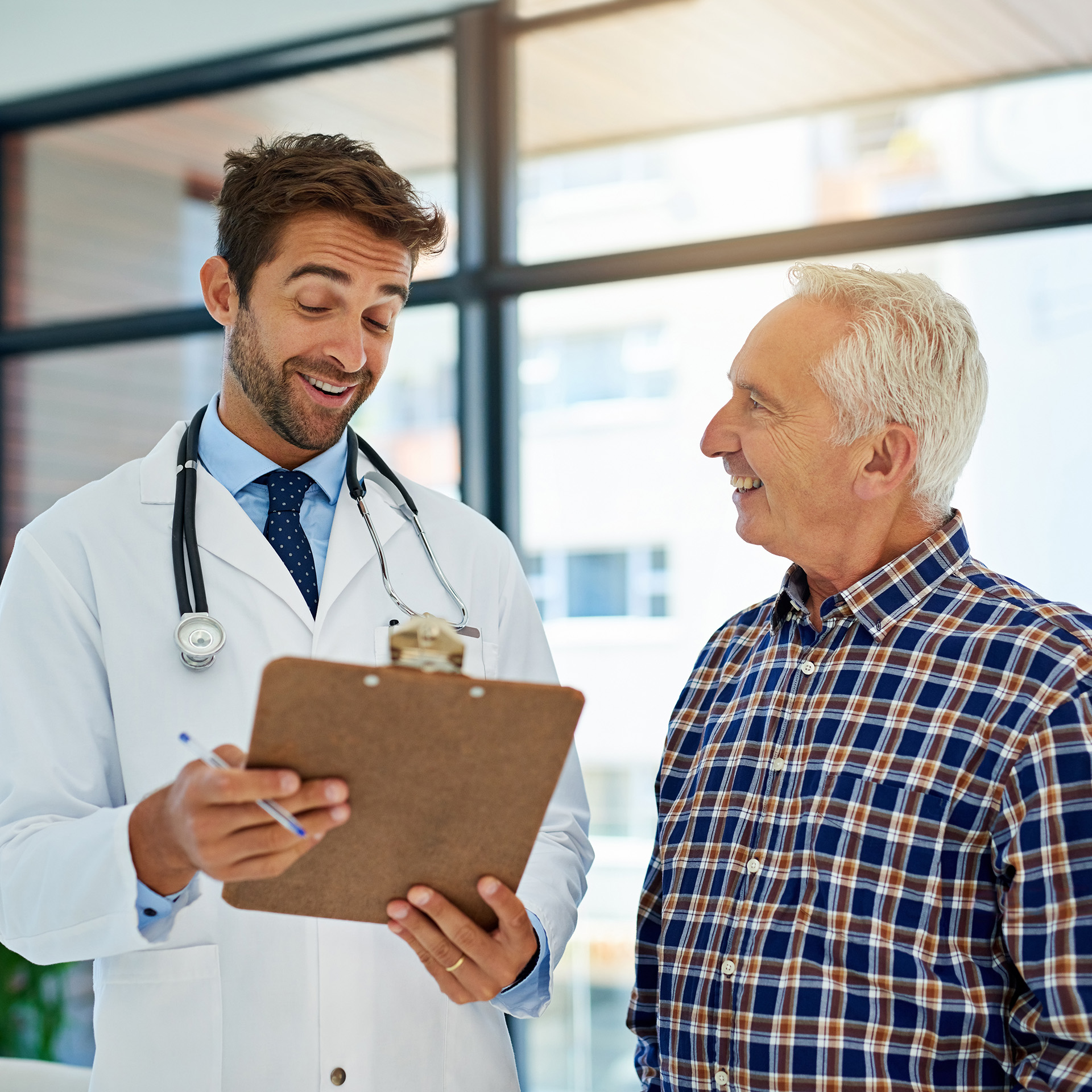 Arzt im Gespräch mit Patienten über Gesundheitsleistungen der betrieblichen Krankenversicherung